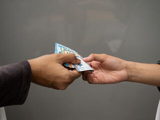 Close-up shot of Indonesian Rupiah notes being exchanged, highlighting the 50000, 20000, 5000, and 2000 denominations.
