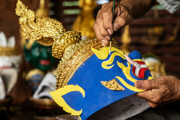 close up of artist painting lakhon khol traditional mask in cambodia