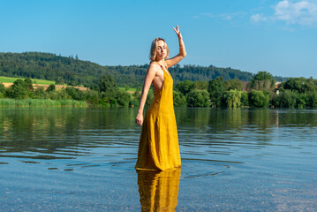 Young woman enjoying nature in lake water on a sunny day in summer