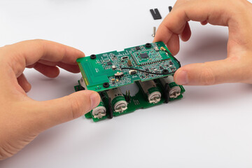 Hands of a master holding an electronic board on a white background