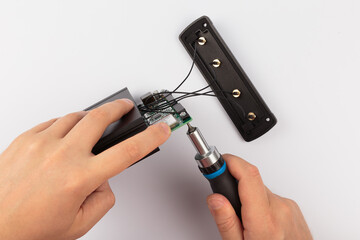 Hands of a master holding an electronic board on a white background