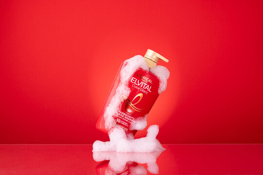 L'Or&eacute;al Paris Elvital Color Glanz Shampoo with Foam on Red Background, a German Haircare Product
