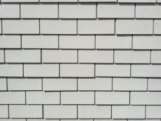 This is a textured light gray brick wall background that can serve various artistic purposes