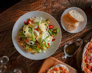 Vegetables salad on a white plate and slices of bread