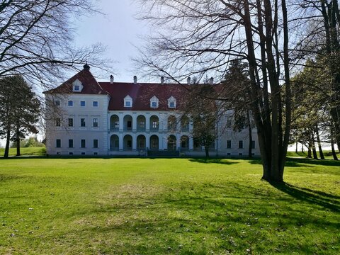 Birzai castle in Lithuania A large, white, two-story building with a red-tiled roof and multiple dormer windows. 