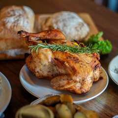 Whole roasted chicken with rosemary on the table