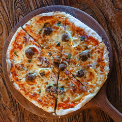 Top view of meat ball pizza with vegetable on wooden table