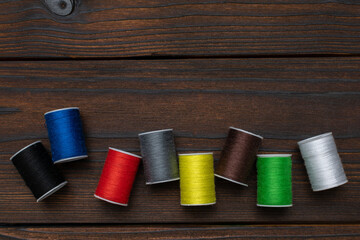Colorful Spools of Thread on Wooden Background: Sewing and Craft Supplies