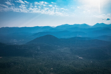 Fototapeta premium Magnificent nature with mountains and forests. Beautiful sunny valley with blue sky in summer. Aerial view with drone.