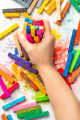 Hands of an artist with soft pastels, bright colours. Colored chalk for creativity, drawing and hobbies.