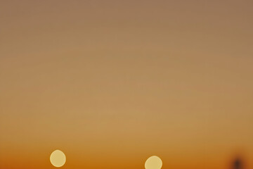 Serene sunset over a tranquil landscape with soft bokeh lights and warm hues in the sky