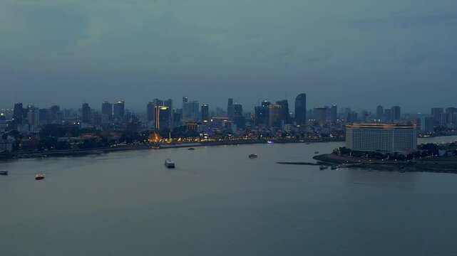 Phnom Penh khm Mekong River skyline at night. Smooth aerial view flight drone