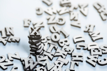 Bled natural wooden letters of the English alphabet in chaotic order on the blue surface.