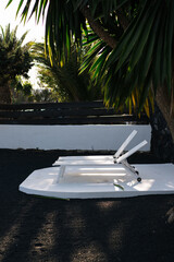 White sun beds on a black volcanic sand