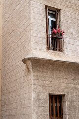 Obraz premium Charming Corner Building with Balcony and Pink Flowers