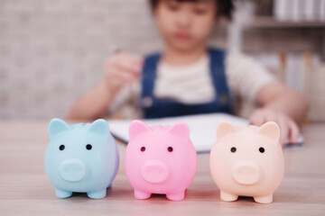 Close up three piggy bank on wooden table