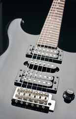 Close up of an electric guitar with shiny black finish