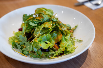 Salad served in a bowl, on the table