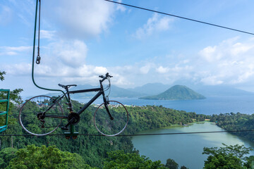 Naklejka premium Bike Hanging Overlooking Scenic Lake and Mountain Landscape on Summer Day