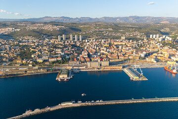 Fototapeta premium Aerial seaside view of Rijeka city against a mountain range at sunset, Croatia 