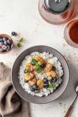 Rice porridge with banana, blueberries, chia seeds and honey sauce on a table, hot and healthy breakfast. Top view