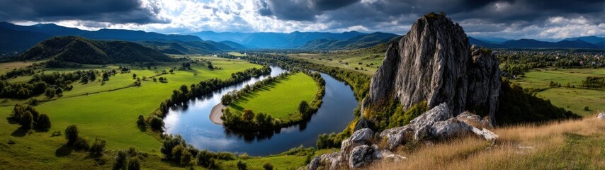 Obraz premium Majestic Nature Landscape with River Curving through Lush Green Fields under Dramatic Sky
