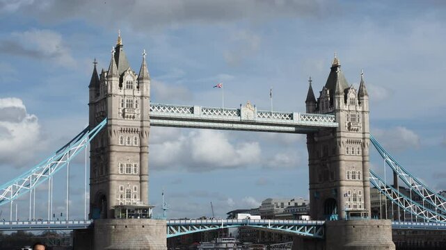 Tower Bridge. Timelapse of Tower bridge in London stands majestically under blue sky. Red double deck bus on London bridge river Thames England. Iconic landmark historic architecture modern urban life