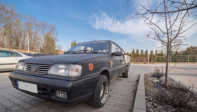 Polska Ostrowiec Świętokrzyski 7 lutego 2025 15:16. POLONEZ TRUCK stary polski samoch&oacute;d dostawczy  na parkingu z gołymi drzewami w tle. Pojazd ma ciemne nadwozie i charakterystyczny pudełkowaty design