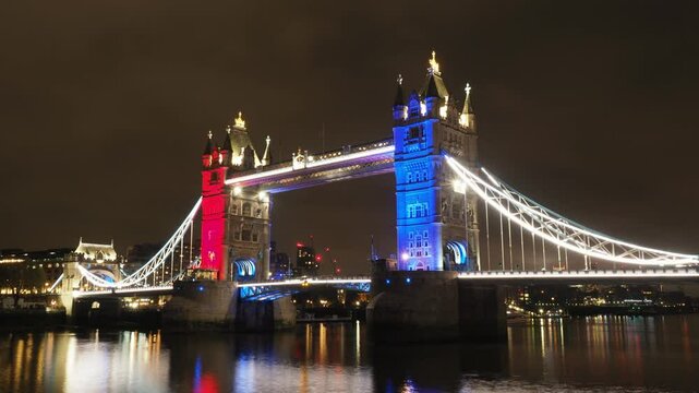 Tower Bridge. Timelapse of Tower bridge in London stands majestically under blue sky. Red double deck bus on London bridge river Thames England. Iconic landmark historic architecture modern urban life