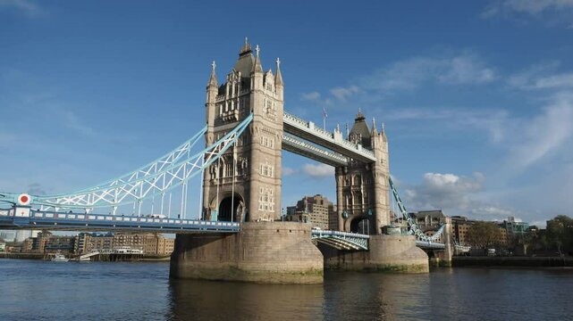 Tower Bridge. Timelapse of Tower bridge in London stands majestically under blue sky. Red double deck bus on London bridge river Thames England. Iconic landmark historic architecture modern urban life