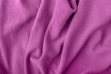 Elegant fabric texture in soft pink color with soft flowing folds and creases