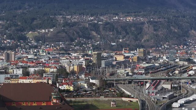 Aerial view of the Bergisel Ski Jump in Innsbruck, Austria, with gradual motion showcasing its modern design and the surrounding snow capped Alps.