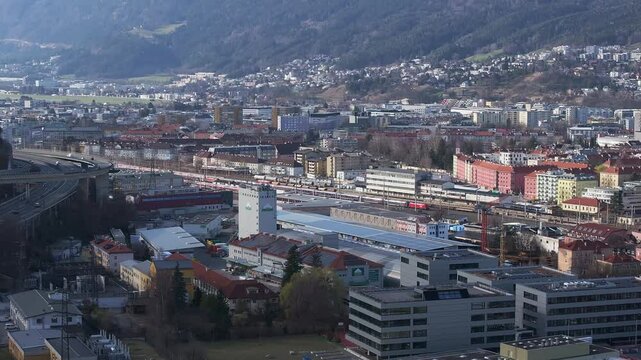 Aerial view of the Bergisel Ski Jump in Innsbruck, Austria, with gradual motion showcasing its modern design and the surrounding snow capped Alps.