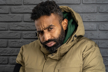 Portrait of a thoughtful, serious young man of African-American nationality with a beard close-up....