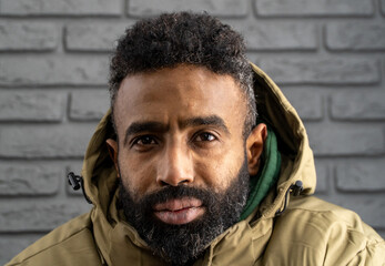 Portrait of a thoughtful, serious young man of African-American nationality with a beard close-up....