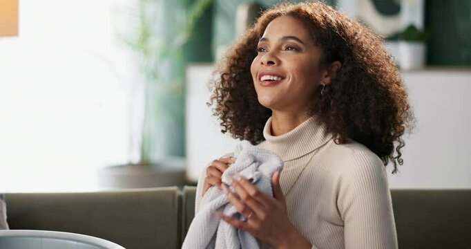 Woman, sofa and house or smell laundry, clean clothing and happy with fabric scent and washing basket in living room. Maintenance, aroma and fresh towel in apartment, satisfied and folding with smile