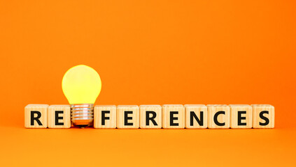 References symbol. Concept word References on beautiful wooden blocks. Beautiful orange table orange background. Yellow light bulb. Business references reference concept. Copy space.