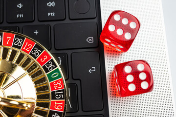 Obraz premium Image depicts an online gambling scene, with a laptop displaying a casino game interface, suggesting a roll-based game like craps Physical dice and keyboard symbolize interaction between digital and