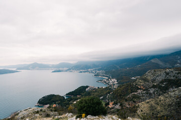 Bay surrounded by high green mountains in fog