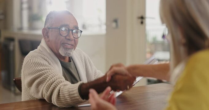 Senior man, documents and signing with handshake for partnership, deal or agreement on insurance at home. Elderly male person shaking hands with client, paperwork or signature for contract at house