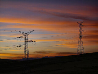 High voltage towers at sunset with beautiful clouds