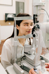 Slit lamp eye and cornea diagnostic at visiting ophthalmology clinic. Light on eye from slit lamp for examination eyes and cornea of girl.