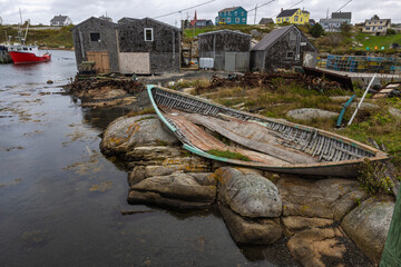 Old wrecked wooden boat laying the edge of water in Peggys Cove Nova Scotia Canada. Landscape photo...