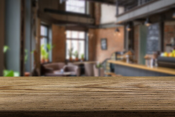 Empty wooden table and blurred background of abstract in front of restaurant or coffee shop for display of product or for montage.