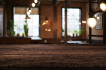 Image of wooden table in front of abstract blurred restaurant lights background.