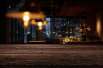 Beautiful dark brown tabletop and evening interior of a cafe or restaurant in the background
