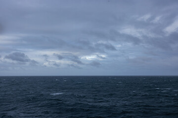 Overcast day open ocean on the horizon calm rippling wavy water surface.