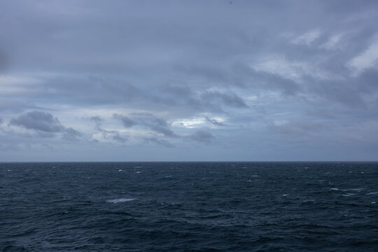 Overcast day open ocean on the horizon calm rippling wavy water surface.