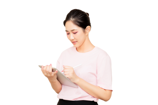 A young woman in a pink shirt is holding a tablet and writing on it with a stylus.