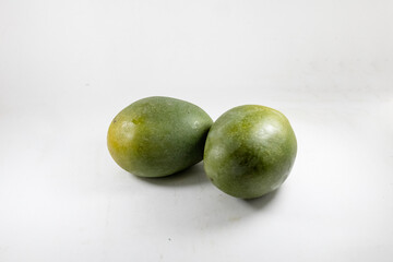 Fresh green mangoes isolated on white background. Perfect for concepts of healthy eating, exotic fruits, minimalistic and health-related projects.